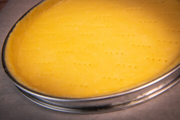 Metal fork makes holes in a raw pastry case in a metal baking tin. High quality photo