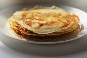 Slavic thin fried pancakes with a crispy golden crust in a stack