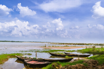 boats on the river with white clouds in blue sky.