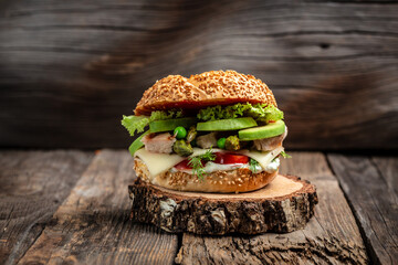 Homemade burger with grilled chicken fillet, asparagus, avocado, tomatoes, peas, cheese and tartar...