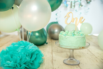 sliver, blue and white decoration for a 1st birthday cake smash studio photo shoot with balloons,...