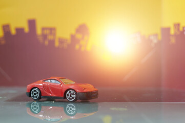 Red Sedan car toy selective focus on blur city background