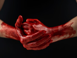 Fototapeta premium Women's fists in blood on a black background. Fist and palm. 