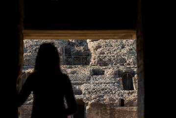 Silueta de mujer observando antiguas ruinas de un teatro romano