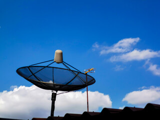 A picture of the daytime sky with clouds and a TV satellite dish.