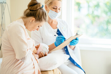 Consultation with a mammalogist or pediatrician. Woman holding and breastfeeding infant baby at...