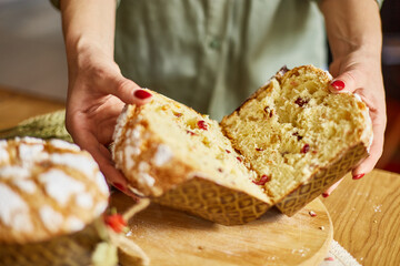 Woman hand cut Easter cake on wooden rustic table.