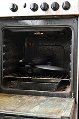 old rusty gas stove in the apartment, open stove door, gas stove from the inside, front view