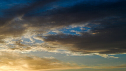 Ciel jaunâtre pendant le coucher du soleil.  On observe d'esthétiques reflets sous des nuages voilés de haute altitude