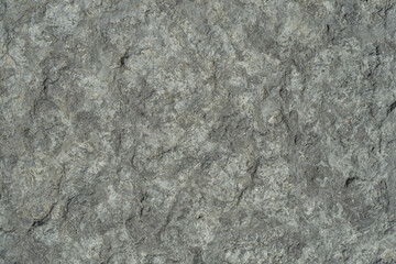 Raw rough dark gray limestone close-up, textured.