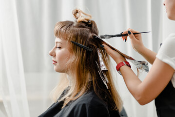 Young attractive woman dying her hair in beauty salon