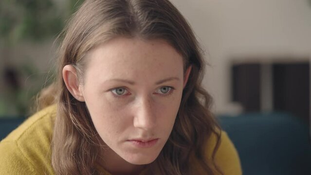 Frustrated woman suffering from abusive relationship, sitting in room alone
