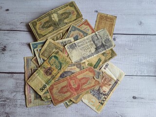 Old Brazilian money, several banknotes of different values and different times, on a wooden table.