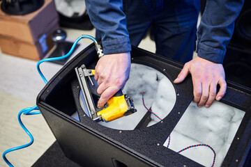 Worker is production speakers and loudspeakers at the factory. Handmade creation of acoustic music systems