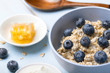 Porridge in a blue place with blueberries on a blue wooden background