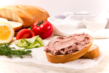 Liver meat pate spread on white bread, on a light background, breakfast, close-up, no people, selective focus,