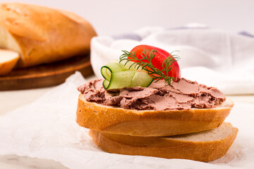 Liver meat pate spread on white bread, on a light background, breakfast, close-up, no people,...