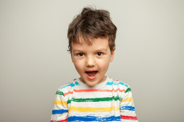 The child laughs. Portrait of a six-year-old Caucasian boy on a yellow background