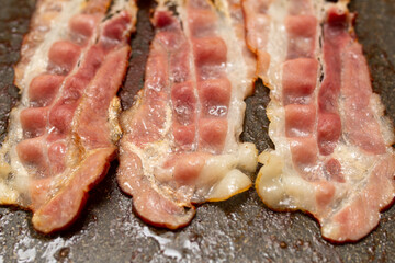 raw pork meat, bacon in a frying pan
