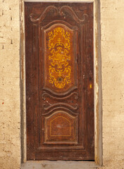 Old single rusted wooden door, wood door with beige color wall, Hurghada, Egypt