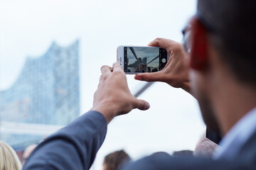Someone taking a picture of the elbphilharmonie in Hamburg