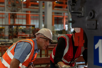 Male engineer caucasian inspects the operation of industrial machines in an industrial plant.
