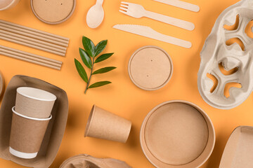 Eco-friendly tableware - kraft paper utensils on orange background. Street food paper packaging, recyclable paperware, zero waste packaging concept. Flat lay, mockup image