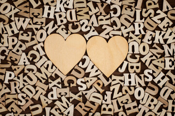 Vintage Wooden Hearts Surrounded by Wooden Letters Background.