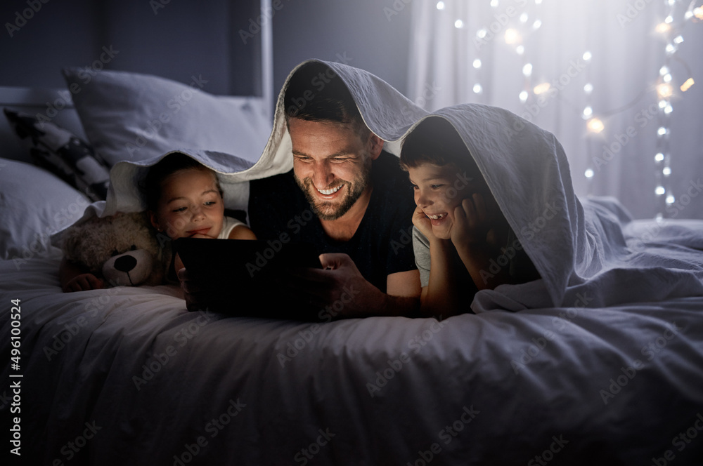 Poster bedtime just turned in to the best time. shot of a father and his two little children using a digita
