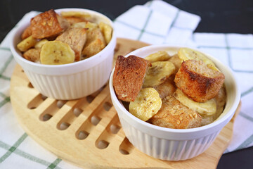Freshly Baked Mouthwatering Banana Bread Pudding in Ceramic Bowls on Wooden Breadboard