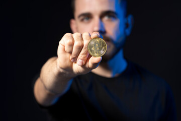 Golden bitcoin coin in a businessman hand. Digitall symbol of a new virtual currency. Man holds bitcoin.