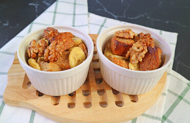 Pair of Fresh Baked Delectable Banana Bread Pudding in Ceramic Bowls on Wooden Breadboard