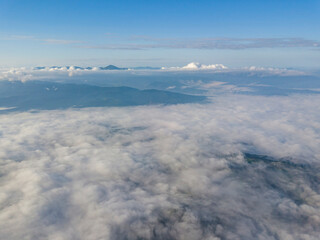Obraz premium High flight above the clouds in the mountains. Aerial drone view.