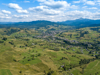 Green mountains of Ukrainian Carpathians in summer. Coniferous trees on the slopes. Aerial drone view.