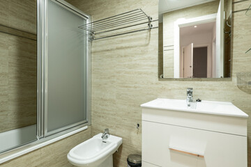 Bathroom with white vanity, wooden furniture and shower cabin with chrome screen