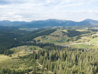 Naklejka premium Green mountains of Ukrainian Carpathians in summer. Coniferous trees on the slopes. Aerial drone view.