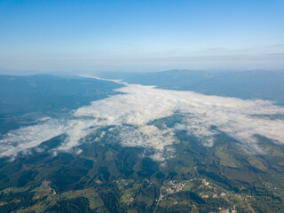 High flight in the mountains of the Ukrainian Carpathians. Fog in the valley. Aerial drone view.