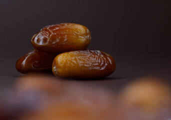 Dates lie on a brown background. Ripe dried dates.