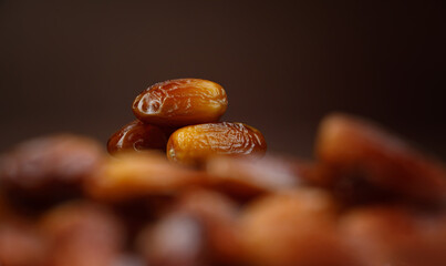 Dates lie on the background of other dates. Ripe dried dates.