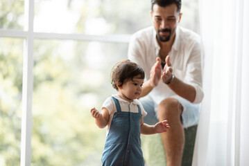 cute toddler little child family concept, baby learning to walk with father and mother to help care and holding hand, first step with childhood parent support, small love portrait little boy at home