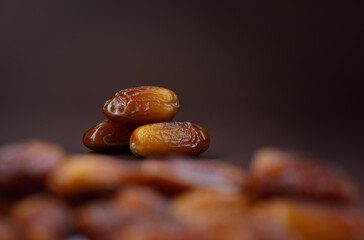 Dates lie on the background of other dates. Ripe dried dates.
