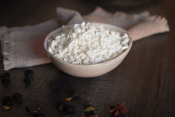Ceramic dishes with a dairy product on a kitchen wooden table.