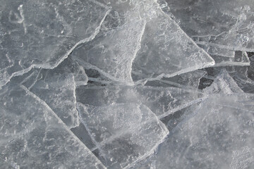 Broken ice pieces on the ground in early spring