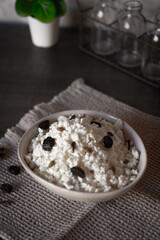 Ceramic dishes with a dairy product on a kitchen wooden table.