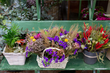 Grupos de flores de distintos tipos y colores en el escaparate de una floristería. 