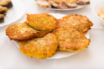 Potato pancakes with sour cream on white plate
