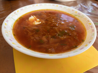 Close view on a bowl with with traditional Ukrainian course - borscht (red-beet soup)