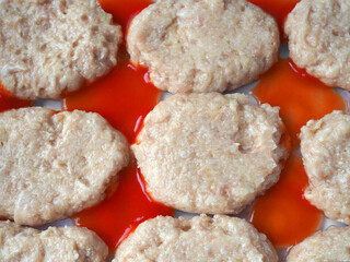 Cooking homemade cutlets for children. Meat with red sauce.