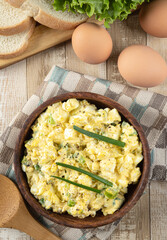 Bowl of egg salad on a wooden table