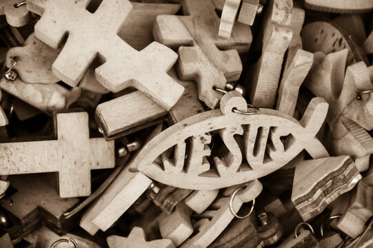 Different wooden crosses and Jesus fish symbol for sale at market in Old City of Jerusalem, Israel. Sepia historic photo.